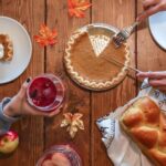 slicing of pumpkin pie placed on wooden surface